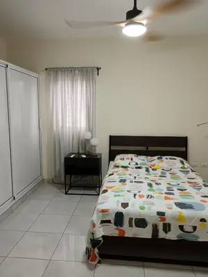 a bedroom with a bed with a comforter on it at Jolie maison in La Romana