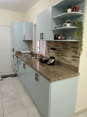a kitchen with white cabinets and a counter top at Jolie maison in La Romana
