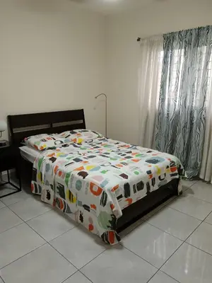 a bed with a comforter on it in a bedroom at Jolie maison in La Romana