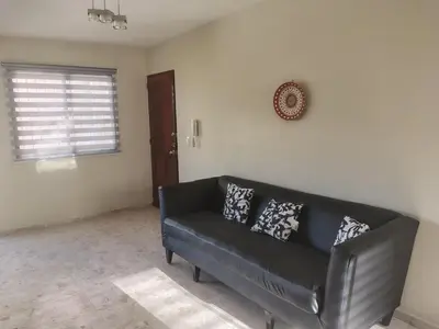 a black leather couch in a living room at Double room with private bathroom in Santo Domingo