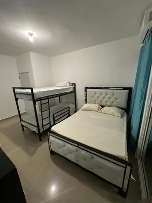 a bedroom with two bunk beds and a table at villa fortuna in Nagua