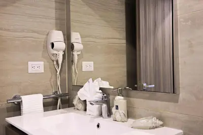 a bathroom with a white sink and a mirror at Elegant 2BR Apt, Steps to Hard Rock in Punta Cana