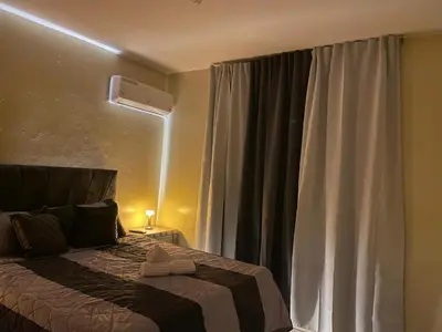 a bedroom with a bed and a window with curtains at Modern 3-bedroom apartment in a gated residential community in Concepción de La Vega