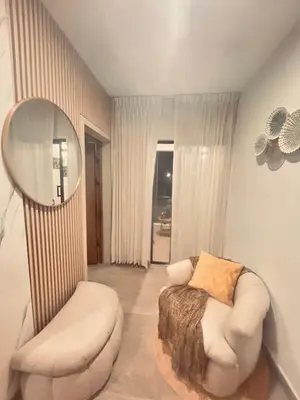 a living room with a white chair and a mirror at El descanso in Higuey