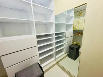 a walk in closet with white shelves and a mirror at Luxurious 4 bedroom apartment near the beach in Ensanche Savica de Mendoza