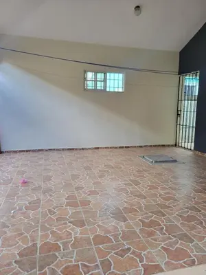 an empty room with a stone floor and a white wall at Spacious house with private parking in San Felipe de Puerto Plata
