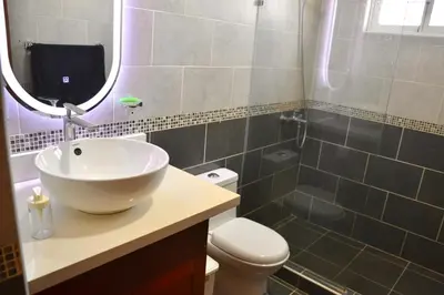a bathroom with a sink and a toilet and a mirror at Comfortable Apartment, Torre Alta in San Felipe de Puerto Plata