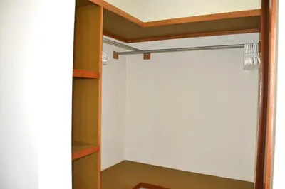 a closet with a white wall and wooden shelves at Comfortable Apartment, Torre Alta in San Felipe de Puerto Plata