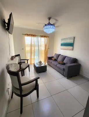 a living room with a couch and a chair at Palma Real Near Cibao Airport in Santiago de los Caballeros