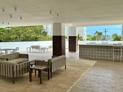 a restaurant with benches and a table and a bar at JuanDolio Penthouse 3 bedrooms Beachfront frente a hemingway in Los Corrales
