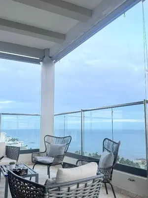 a room with chairs and a table and windows at JuanDolio Penthouse 3 bedrooms Beachfront frente a hemingway in Los Corrales