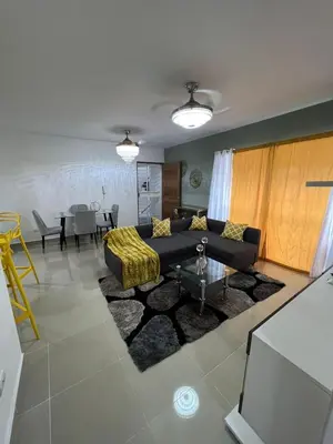 a living room with a couch and a table at Beautiful residential area near Avenida España in Los Mameyes