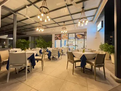 a dining room with tables and chairs and lights at Ristorante simaredo in Punta Cana