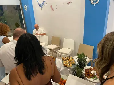 a group of people sitting around a table with food at Ristorante simaredo in Punta Cana