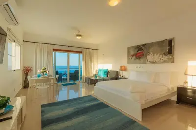a bedroom with a large bed and a living room at Cozy Beach Front Apt, King Bed. in Cabarete