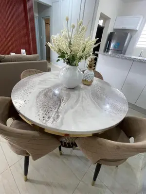 a round table with a vase of flowers on it at Apartamento acoger en Santo Domingo este in Hainamosa