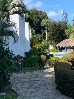 a path leading to a resort with a swimming pool at Karibisches Familienparadis in Gated Comunity in Sosua