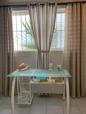 a blue table in front of a window with curtains at Karibisches Familienparadis in Gated Comunity in Sosua