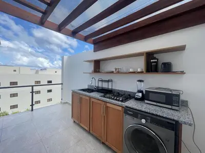 a kitchen with a washer and dryer on a balcony at Beautiful Penthouse in Sunset Puerto Plata Gym, Pool in Puerto Plata