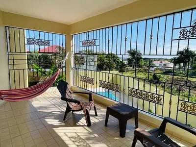 a balcony with a hammock and a large window at 360 View House with Private Pool Jacuzzi and Terrace in Puerto Plata