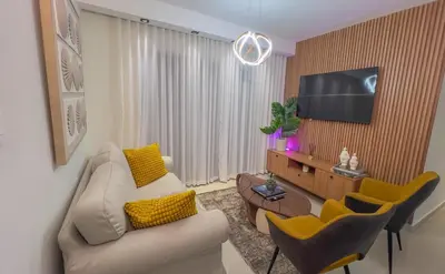 a living room with a couch and a flat screen tv at San Isidro Urban suite in Juan López
