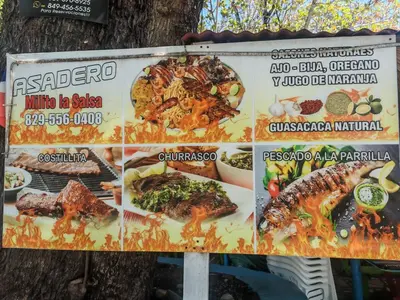a sign in front of a tree with food on it at 3 Bed, 2 Bath, Hot Water, Apartment near the beach, in Bani in Baní