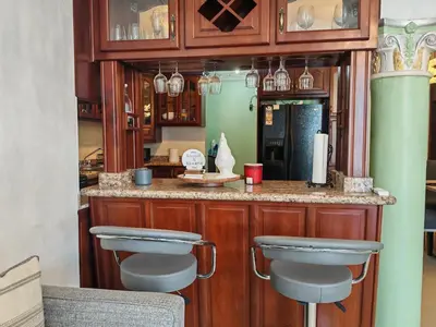 a kitchen with a bar with stools in it at 3 Bed, 2 Bath, Hot Water, Apartment near the beach, in Bani in Baní