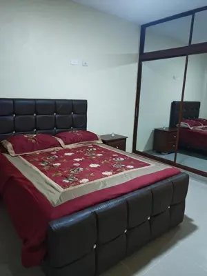 a bedroom with a large bed with a red comforter at Cozy apartment, AC, Wifi, 2BR, 2Bath, Bani, 1-B in Baní