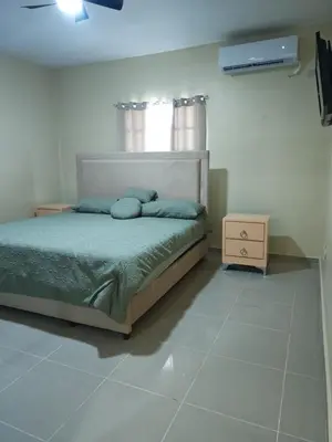 a bedroom with a bed and a dresser in it at Cozy apartment, AC, Wifi, 2BR, 2Bath, Bani, 1-B in Baní