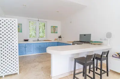 a kitchen with blue cabinets and a counter with stools at Las Marinas Los Nmada, 80 meters from Coson beach in Las Terrenas