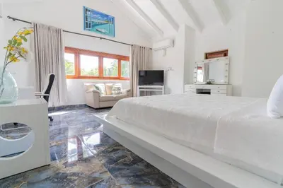 a white bedroom with a bed and a couch at Tropical Villa in Playa Bonita in Pasos Del Mar in Las Terrenas