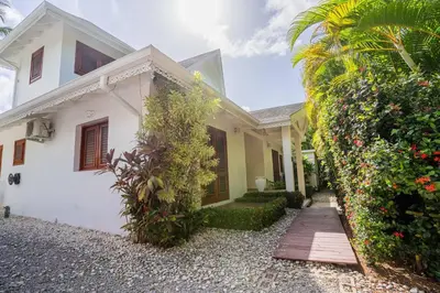a white house with a walkway in front of it at Tropical Villa in Playa Bonita in Pasos Del Mar in Las Terrenas