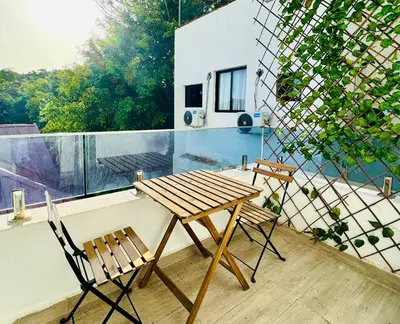 a wooden table and two chairs on a balcony at Modern Central Ocean View and Jacuzzi Apartment in Santo Domingo