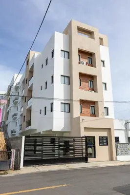 a tall white building on the side of a street at Prado Garden Hotel in Monte Plata