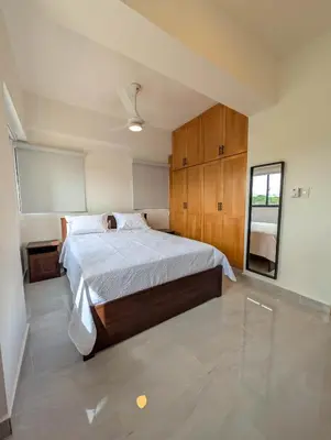 a bedroom with a bed and a ceiling fan at Prado Garden Hotel in Monte Plata