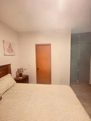 a bedroom with a bed and a wooden door at El descanso in Mata Chalupe