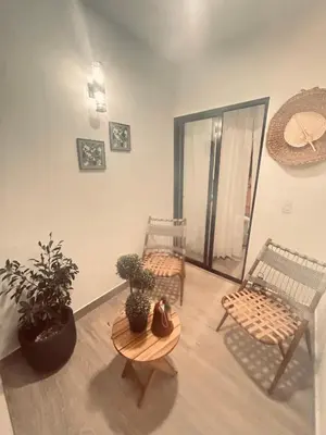 a room with two chairs and a table and plants at El descanso in Mata Chalupe