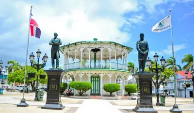 a building with two statues in front of it at Stylish Apartment Steps from Puerto Plata Malecon in San Felipe de Puerto Plata