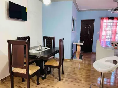 a dining room with a black table and chairs at Stylish Apartment Steps from Puerto Plata Malecon in San Felipe de Puerto Plata
