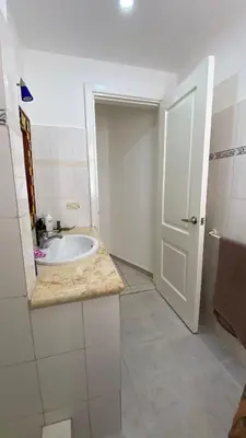a white bathroom with a sink and a door at Casa Mattia in La Laguna