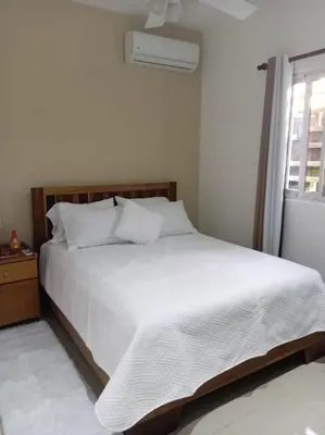 a white bed in a white bedroom with a window at Casa Brisa del Río in Las Terrenas