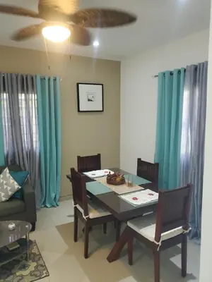 a dining room with a table and chairs and blue curtains at Casa Brisa del Río in Las Terrenas
