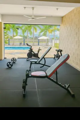 a gym with several exercise bikes and a pool at Boca chica playa y sol in Boca Chica