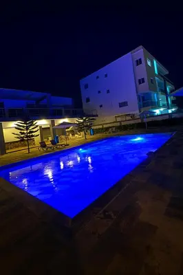 a swimming pool at night with a building at Boca chica playa y sol in Boca Chica