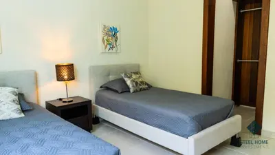 a bedroom with two beds and a lamp on a table at Eden Caribe Punta Vana in Punta Cana