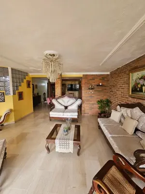 a living room with two couches and a brick wall at Villa Mila en Santo Domingo in Los Tres Ojos de Agua