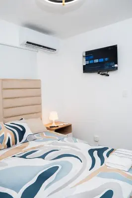 a bedroom with a bed with a television on the wall at vacation apartment BANI PERAVIA in Boca Canasta