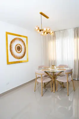 a dining room with a table and chairs and a chandelier at vacation apartment BANI PERAVIA in Boca Canasta