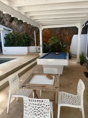 a patio with a pool table and two chairs at Villa Mirna in Las Terrenas