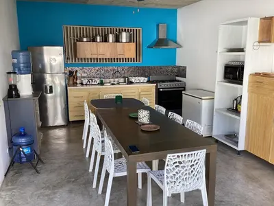 a kitchen with a wooden table and white chairs at Villa Mirna in Las Terrenas